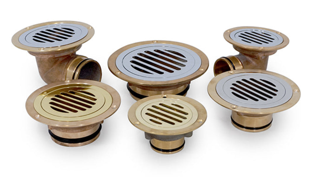 A collection of bronze-colored cast bronze vinyl flanges with different sizes, featuring a grid pattern on the top surface.