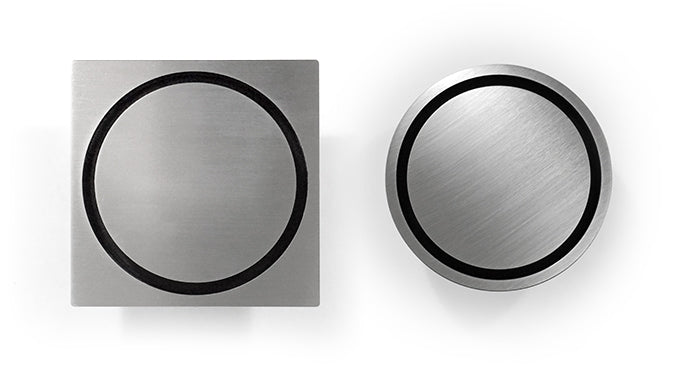 Two views of a stainless steel bathroom drain grate, one showing the top view with a round-in-round design and the other showing a side view, both with a silver finish.