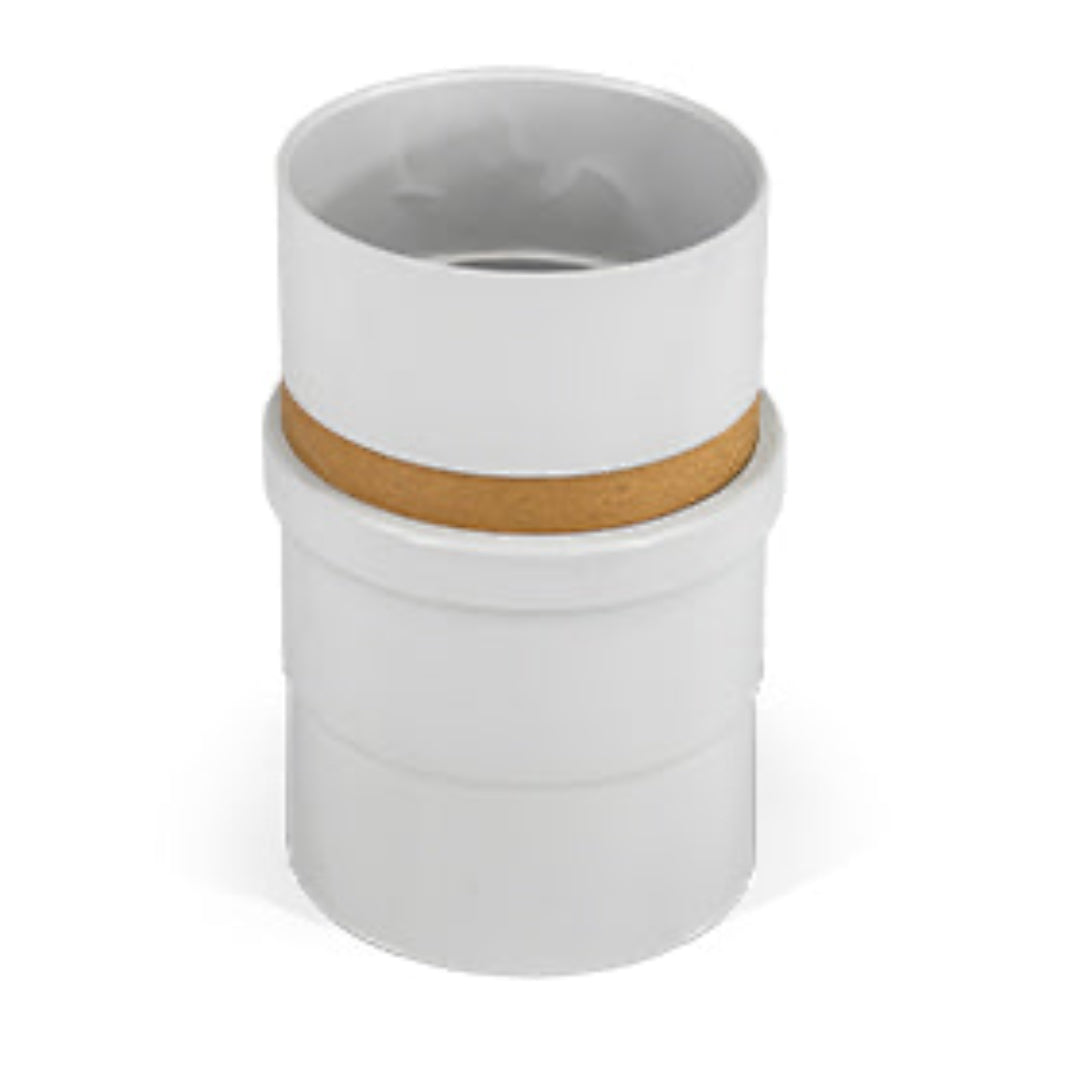 A white UPVC DWV pipe expansion joiner and coupling assembly with a cardboard spacer visible.