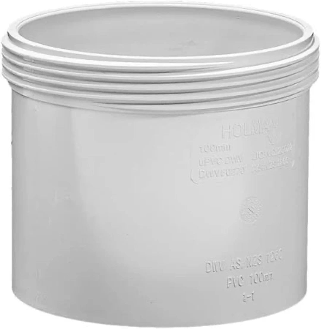 A white, threaded access coupling for plumbing, with embossed text on the side.